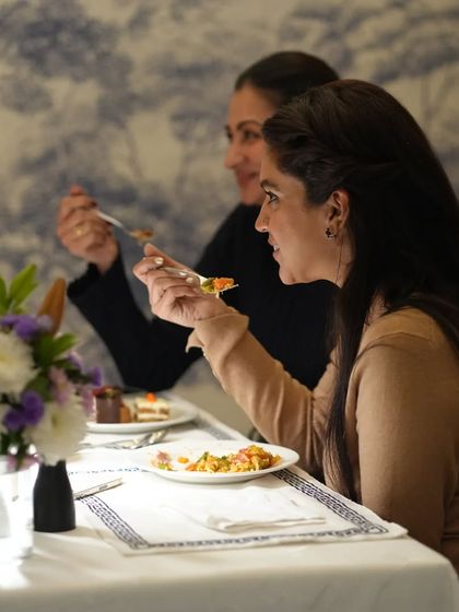 Guests enjoying a meal together in our indoor dining space. The setting is designed to encourage conversation and connection.