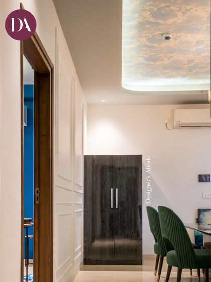 A view from the passage into the dining room, where deep green chairs and a sky-printed ceiling wallpaper create a unique and chic atmosphere. This shows our approach to designing every part of the home, including transitional spaces.