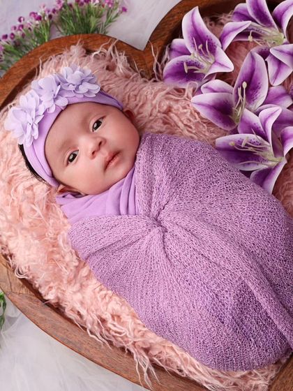 A beautiful newborn girl, awake and looking at the camera. Her big, curious eyes are captivating.