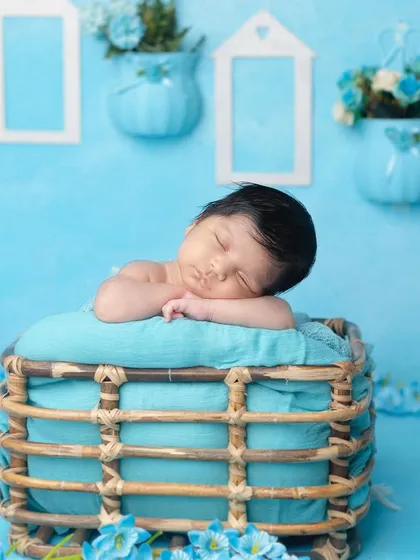 A side angle of the basket pose, showing the baby's sweet sleeping face.