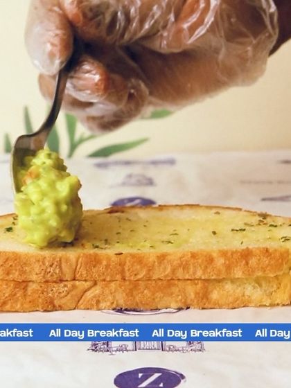 The first step to a perfect avocado toast is the perfect base. Here, I'm spreading fresh, house-made guacamole onto a slice of garlic-rubbed toast.