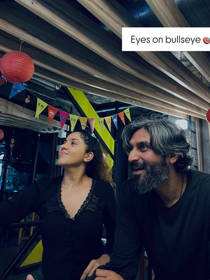 Eyes on the bullseye. A moment of focus and fun between two friends as they take aim at the dartboard.