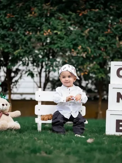 This outdoor setup includes a personalized chalkboard, adding a lovely custom touch to a first birthday shoot.