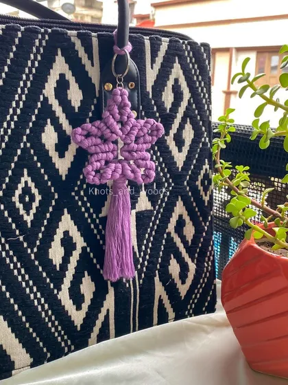 A little macrame star to brighten your day. This star-shaped keychain is knotted with soft purple cotton cord and makes for a magical bag charm or gift.