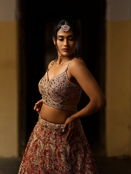 A dramatic and moody shot of Poornima. The lighting and her pose create a high-fashion, editorial feel.