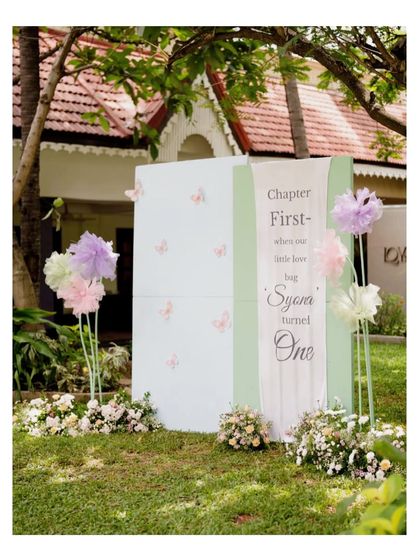 A unique entrance piece designed as a giant storybook. The prop reads "Chapter First - where our little love bug Syora turned One," setting a magical narrative from the moment guests arrive.