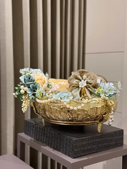 The full view of the golden elephant bowl hamper, decorated with soft blue and cream flowers. It’s a grand gesture for corporate or personal gifting during the festival of lights.