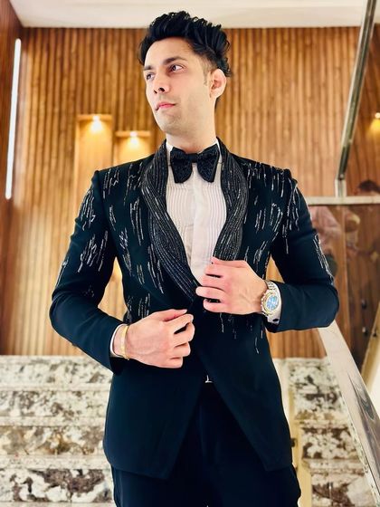 A client looking sharp and stylish in our custom-designed tuxedo. The jacket features a unique pattern of silver beadwork on a black base, perfect for making a statement.