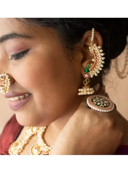 A side profile of a client wearing a full set of traditional accessories: the Nath, the Karnaphool, and the Khopa.