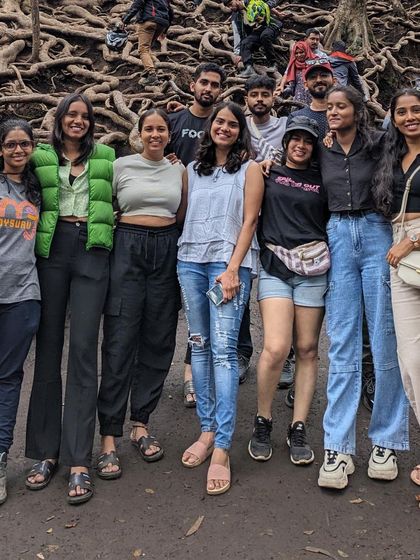 Friends posing together among the tangled roots of the forest trees.