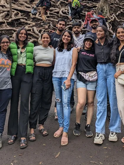 Friends posing together among the tangled roots of the forest trees.