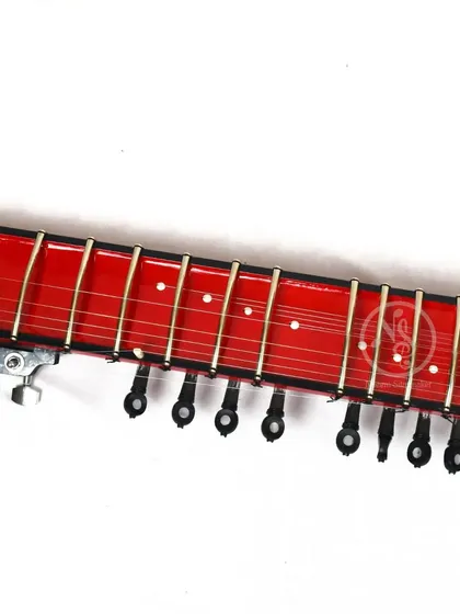 The fretboard of the red Zitar. The frets are metal, just like on a traditional sitar, to allow for meend (bending notes).