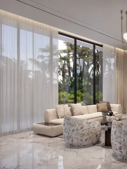 This view highlights the floor-to-ceiling windows that connect the interior with the lush palm trees outside, emphasizing a tropical modern luxury aesthetic.