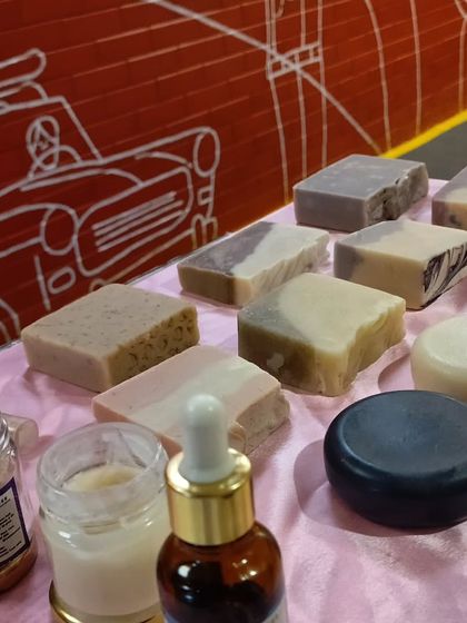 A selection of my handmade soap bars on display. You can see the variety of natural colors and textures, from smooth rounds to rustic, hand-cut rectangles.