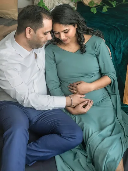 An intimate portrait of the couple, their heads close together, sharing a private moment. This shot beautifully captures their connection and shared anticipation in the cozy studio environment.