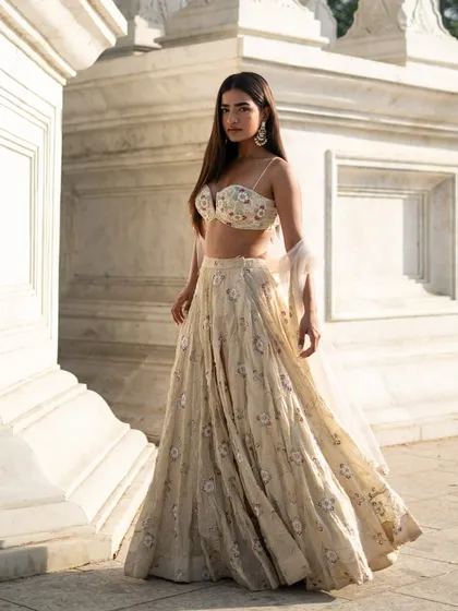 Drench yourself in pure elegance with this ivory floral lehenga. The soft tones and exquisite handwork make it a beautiful choice for a sophisticated event.