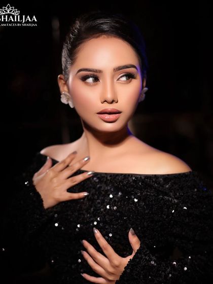 A classic cocktail look with an off-shoulder sequined black dress. The makeup is glamorous with a focus on flawless skin and defined eyes.