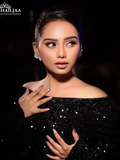 A classic cocktail look with an off-shoulder sequined black dress. The makeup is glamorous with a focus on flawless skin and defined eyes.