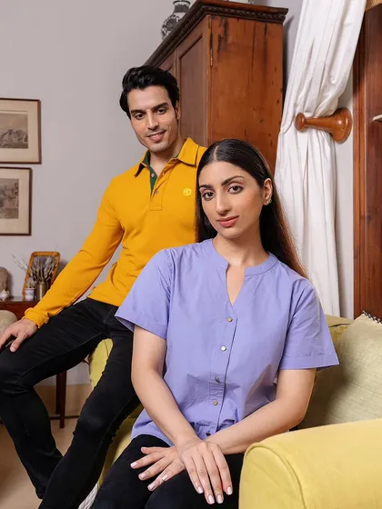 A couple posed for the MG Motor apparel campaign. The shot is framed to feel like a candid moment at home, highlighting the comfortable and casual nature of the clothing line.