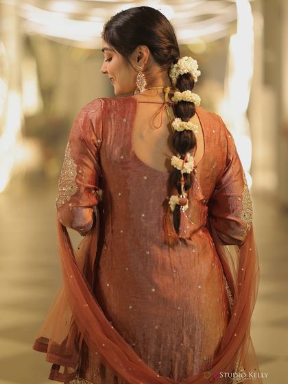 The back view of my puja outfit, showing off the beautiful braided hairstyle adorned with fresh flowers. It's a great way to add a traditional touch to any look.