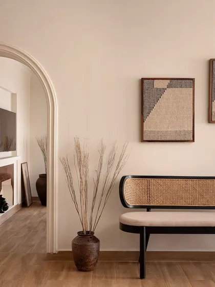 An elegant entryway vignette featuring a custom rattan bench. The arched passage provides a beautiful transition into the living area, demonstrating my focus on creating a natural flow throughout the home.