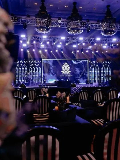 A view of the Sangeet stage from the audience. The striped chairs and dramatic stage lighting created a cohesive and visually stunning experience for all the guests.