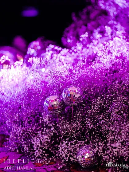 A close-up of disco balls nestled within a cloud of purple-lit baby's breath, a fun detail that perfectly captured the glamorous party vibe of the Sangeet.