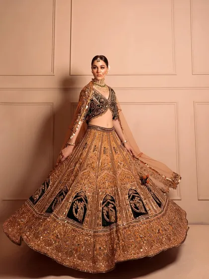 A majestic, twirling shot of a bride in a golden and black lehenga. I styled this to showcase the dramatic flair and intricate patterns of the skirt.