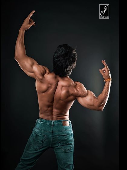 A slightly different angle of the back pose, emphasizing the symmetry and separation between muscle groups. This type of shot is crucial for judging and for tracking transformation progress.