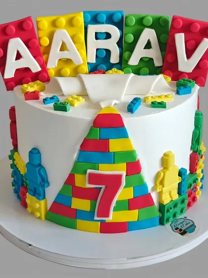 A colorful Lego-themed cake for a 7th birthday. The cake is decorated with edible Lego blocks and minifigures, making it a builder's dream.