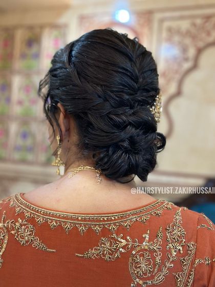This low, textured bun incorporates a central braid for added detail. It's a sophisticated style that works well for formal evening events, keeping hair neatly off the shoulders.