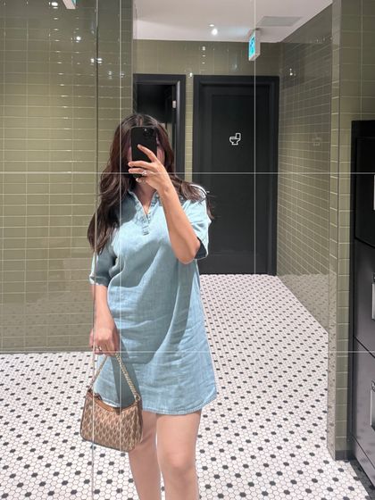 This mirror selfie shows a full look featuring a Calvin Klein denim dress and a Michael Kors bag. It's a quick, effective way to show how I style different brands together for a cohesive summer outfit.