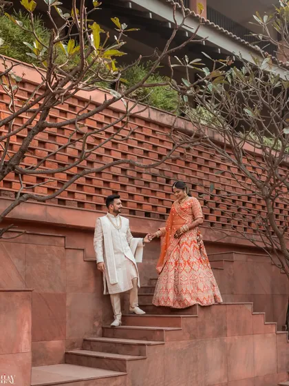 A candid moment captured as the couple descends a grand staircase. The natural interaction and the architectural elements combine to create a photo that feels both grand and personal.