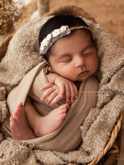 I am in love with the neutral, earthy tones of this setup. This baby is sleeping peacefully in a basket, wrapped in soft, natural fabrics.