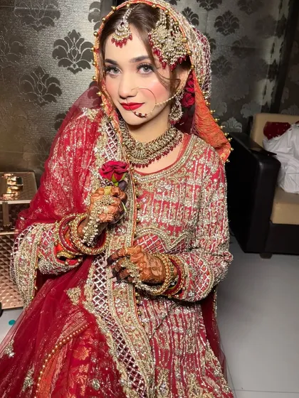 My beautiful bride Huda holding a single red rose. We opted for a soft Pakistani-style makeup with a complementary red lip to tie the whole look together.