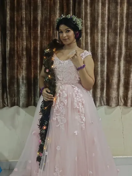 Live out your fairytale dreams with this Rapunzel-inspired look, featuring a lovely pink gown with floral applique.