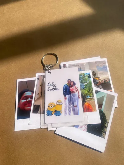 This combo features a custom keychain with a "baby brother" illustration and photo, paired with a set of Polaroid prints. It's a great gift for celebrating family.