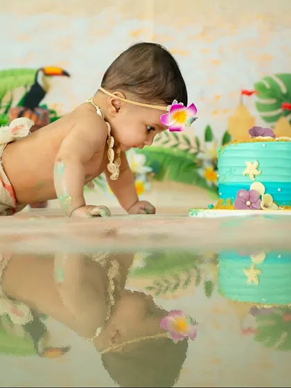 A Moana-themed cake smash is perfect for little adventurers. Here she is, crawling towards her ocean-blue cake, ready for a tropical treat.