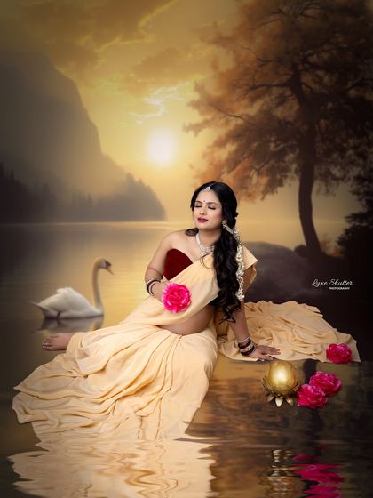 A beautiful moment of connection with nature in this culturally themed shoot. The mother-to-be holds a pink rose, adding a touch of delicate color to the warm, golden-hour scene.