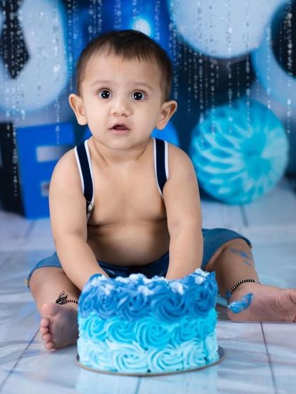 The "Boss Baby" is ready for his cake. This shot, taken just before the smashing began, shows off the adorable blue-themed setup and the birthday boy's serious expression.