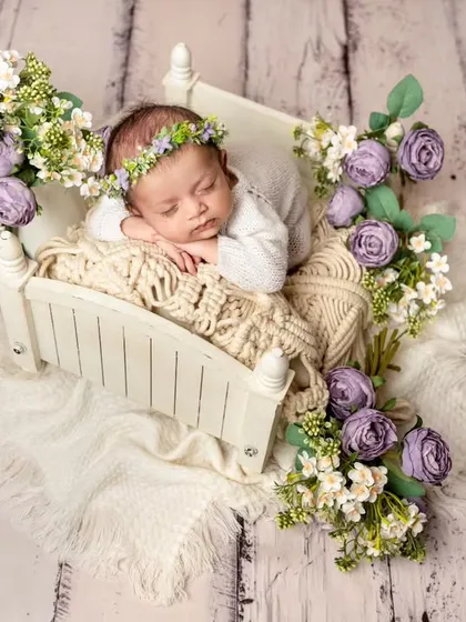 For a touch of elegance, I design elaborate floral setups like this one. Nestled in a tiny bed surrounded by fresh flowers, your baby becomes the centerpiece of a beautiful, artistic portrait.