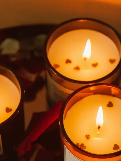 Set a warm, romantic mood with my special occasion candles. Pictured here are three of my scented jar candles, lit to show their beautiful glow, with tiny hearts floating on the melted soy wax. These are a customer favorite for Valentine's Day and anniversaries.