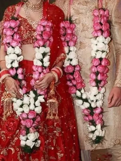 Here is an example of how I match the jaimalas to the couple's attire. These garlands use a beautiful combination of pink and white roses to complement both the bride's red lehenga and the groom's cream sherwani.
