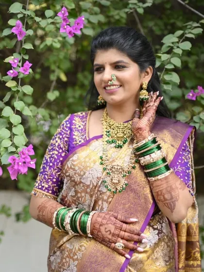 This bride looks stunning in her purple and gold saree, with green bangles that make her dark mehendi stain pop.