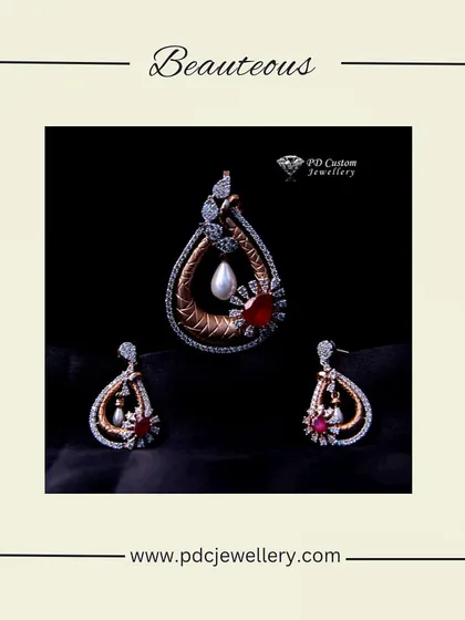 A beauteous diamond pendant set in 18kt gold. The design features a teardrop shape with ruby and pearl details, offering a touch of vintage charm.