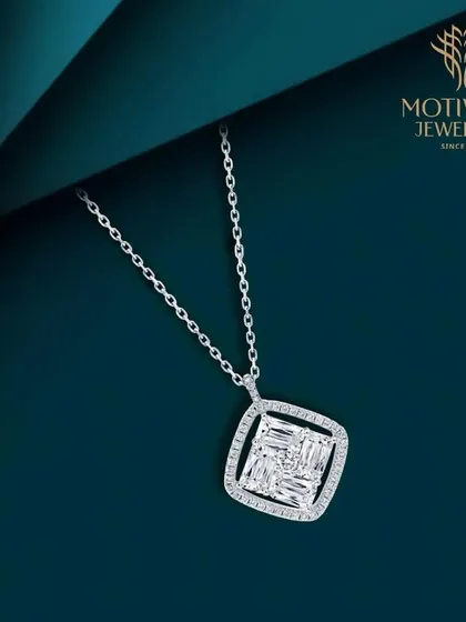 A modern and chic pendant featuring an illusion-set square of baguette diamonds, framed by round diamonds on a simple chain.