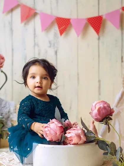 A moment of calm amidst the props. This shot captures her beautiful, wide-eyed gaze in a charming, rustic setting.
