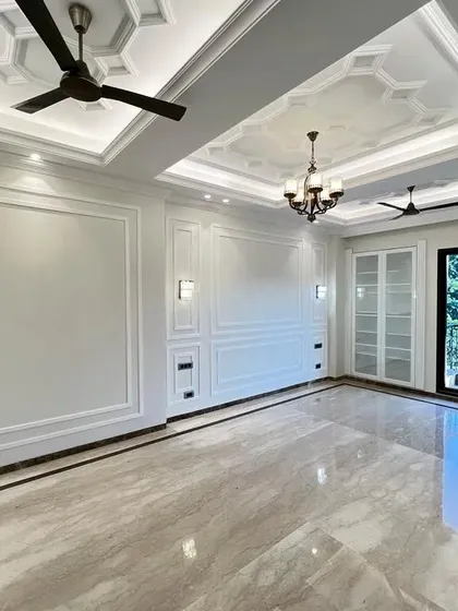 A perfect example of how we balance classic and modern elements. The room features traditional wall mouldings and a coffered ceiling with a chandelier, while large windows bring in plenty of natural light, creating a bright and airy atmosphere.