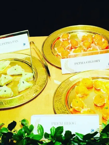 A selection of traditional Bengali sweets like Pista Sandesh and Putra Jalebi, elegantly presented on golden plates. We take pride in offering authentic regional mithai as part of our menu.