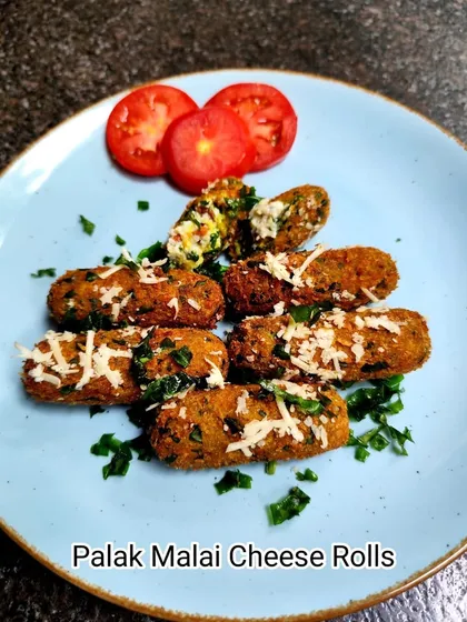 Enjoy our Palak Malai Cheese Rolls, garnished with fresh herbs and grated cheese. They are the perfect warm and savory snack to enjoy anytime.